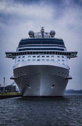 A vertical closeup shot of a ship on the beautiful sea under the cloudy sky