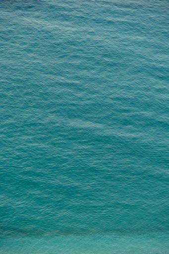 An aerial shot of the tranquil turquoise water of the Mediterranean Sea on a sunny day