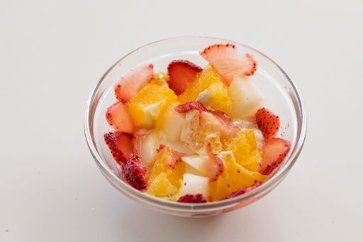 A closeup shot of a bowl of fruit salad made with strawberries and oranges