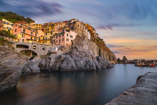 A Beautiful sunset over a colorful village on a cliff with the sea below