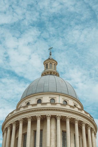 A vertical low-angle of the Pantheon monument dome against cloudy sky background