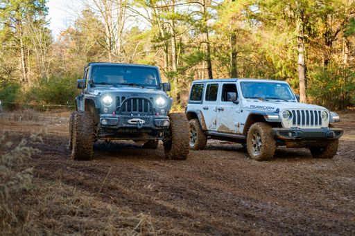 Two Jeep Rubicons on a muddy trail for race.