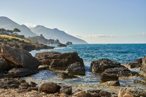 A wavy beach full of rocks on a sunny day
