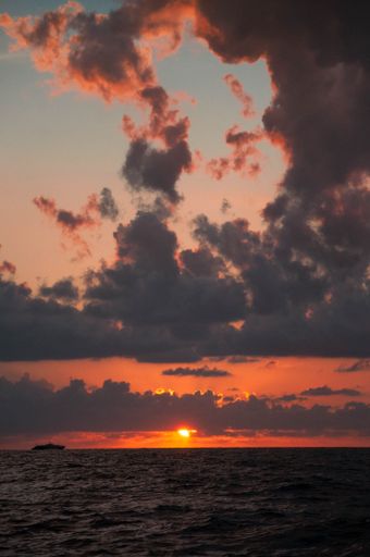 A tranquil scenery of a sea with sunset in the distance, Italy, vertical shot