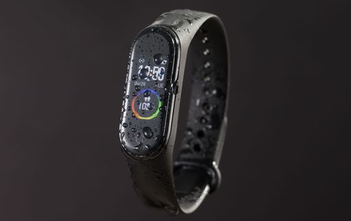 The digital display of a black smart watch bracelet before a dark background