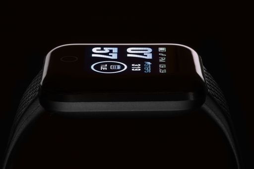 The digital display of a black smart watch bracelet before a dark background
