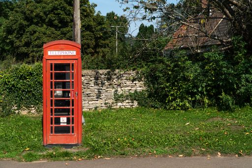 A traditional English red telephone box in village in Gloucestershire, England, UK