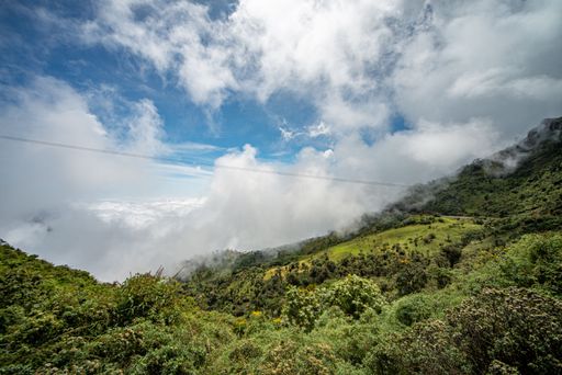 Beautiful shot of landscape, tropical mountain forest and hills covered with green lush trees under cloudy blue sky