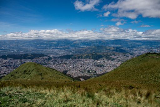 A beautiful scenery of a cityscape surrounded by mountains under blue cloudy sky in Quito, Ecuador