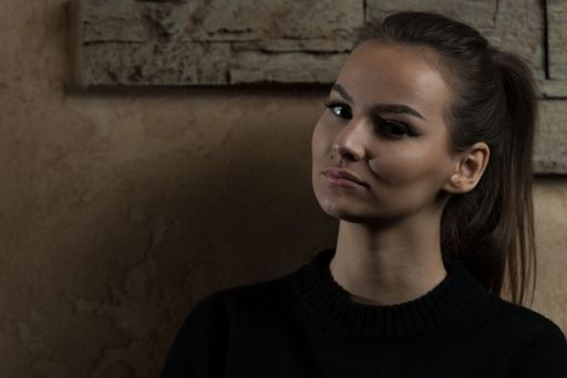 A Portrait of Pretty Woman Standing Against a brick Wall Background
