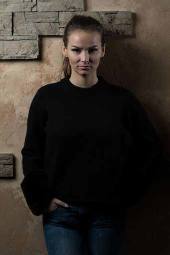 A vertical Portrait of Pretty Young Woman Standing Against Brick Wall
