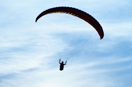 Close up shot of paraglider pilot in blue sky near Cologne, Germany