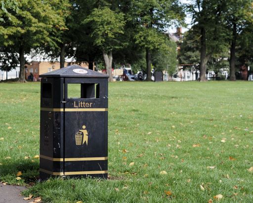 A close-up shot of a trash can in a park
