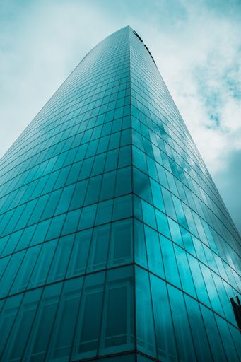 A low angle shot of a modern blue building with glass windows