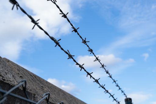 A low angle shot of a wire barb on a blue sky background