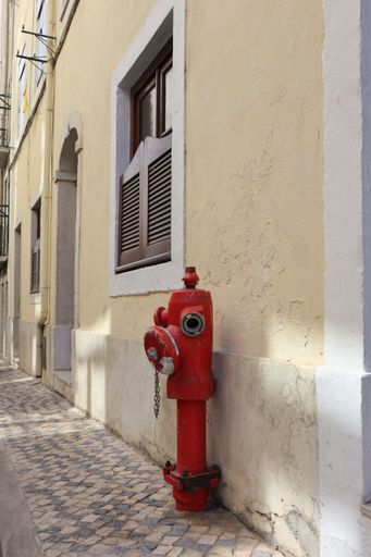 Fire hydrant in Lisbon, Portugal, in front of yellow wall