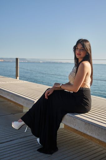 A vertical shot of a Caucasian woman wearing en evening dress and posing