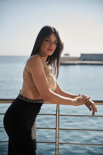 A vertical shot of a Caucasian woman wearing en evening dress and posing