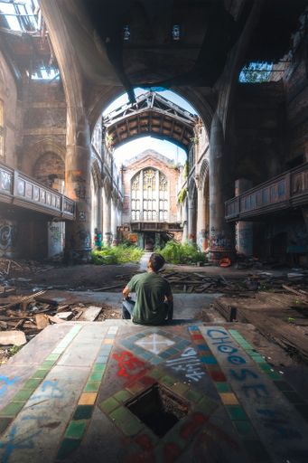 A vertical shot of a male admiring an old abandoned church in Indiana