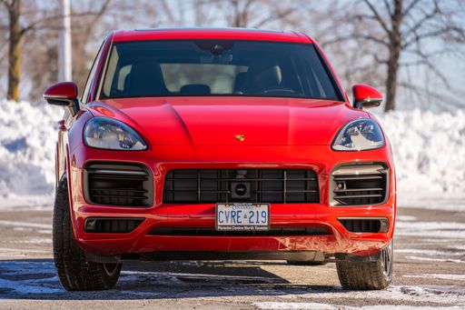 A Red Porsche Cayenne in a parking low on a sunny day during the winter