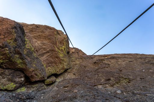A low angle shot of rocks with cables for climbing