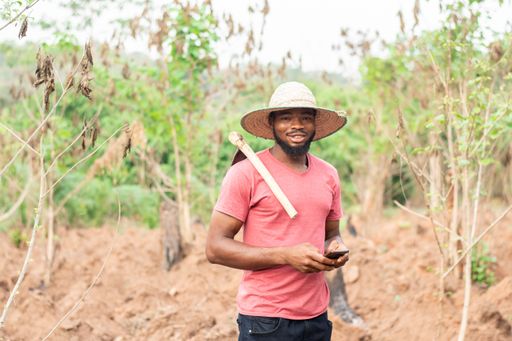 african farmer making use of his phone to text or message