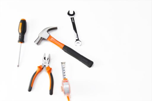 A top view of an orange and black mechanic hand tool set against a white background