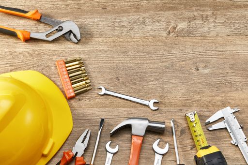 A top view of an orange and black mechanic hand tool set against a wooden background