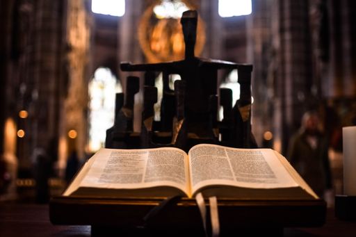 A closeup shot of an open Bible on a stand inside a Church
