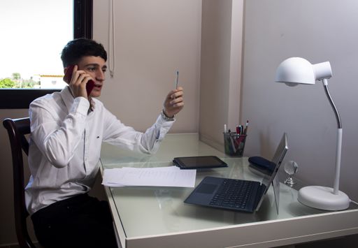 A Caucasian man working in the office with a laptop
