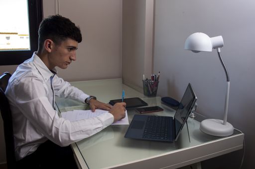 A Caucasian man working in the office with a laptop