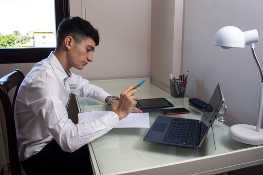 A Caucasian man analyzing statistics on a laptop in the office