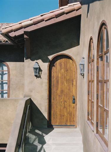 An exterior shot of a brown old building house with a door with windows, vertical shot