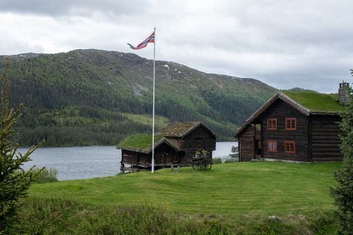 Wonderful landscapes in Norway. Vestland. Beautiful scenery of houses with grass roof. Norwegian traditional architecture. Mountains, rocks and snow