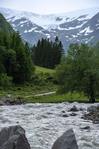 Wonderful landscapes in Norway. Vestland. Beautiful scenery of Buerbreen glacier. Sandvevatnet lake. Mountains, trees, rocks and houses in background
