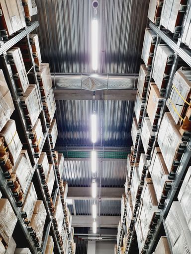 A low-angle shot of an illuminated corridor of an industrial warehouse.