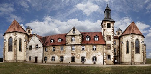 A panoramic view of hotel Kloster Haydau against a cloudy blue sky in Germany