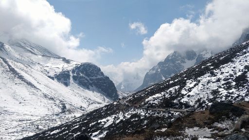 A scenic shot of snowy mountains under the cloudy sky