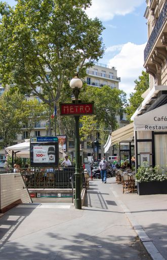 Paris, France - Friday 29th July 2022: portrait view of entrance of metro station with art deco metro signs on the lamp posts. High quality photo