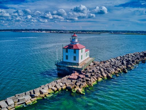 A drone shot of the Ashtabula Harbor Light building under a cloudy sky in Ohio, USA