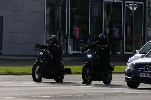 Two black motorcycles next to each other on a road