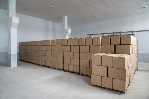 A pile of craft boxes stacked on top of each other in a white warehouse