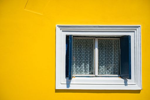A beautiful shot of a window on a yellow wall background