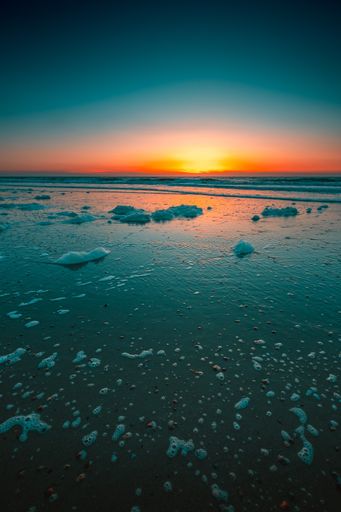 A vertical shot of the beautiful sunset over the sea captured in Domburg, Netherlands