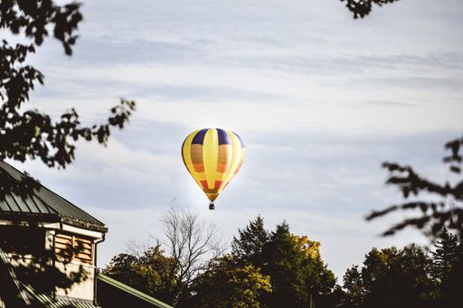 A beautiful shot of a yellow hot air balloon in the cloudy sky