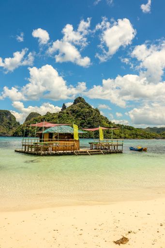 A vertical shot of a wooden bar in the ocean at the beautiful coastline of El Nido