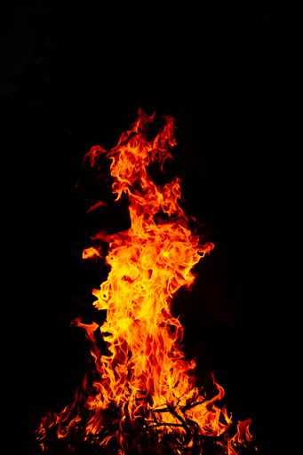 A beautiful vertical shot of a large burning fire at night
