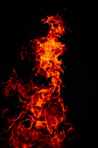 A beautiful vertical shot of a large burning fire at night