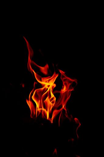 A vertical shot of beautiful burning flames at night