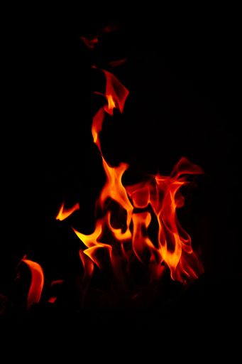 A vertical shot of beautiful burning flames at night